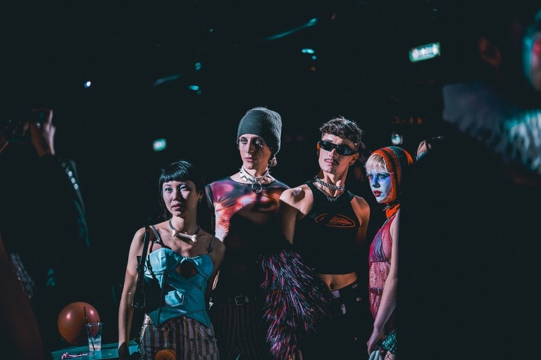 Vibrant fashion models at a night party, showcasing bold, edgy streetwear and accessories.