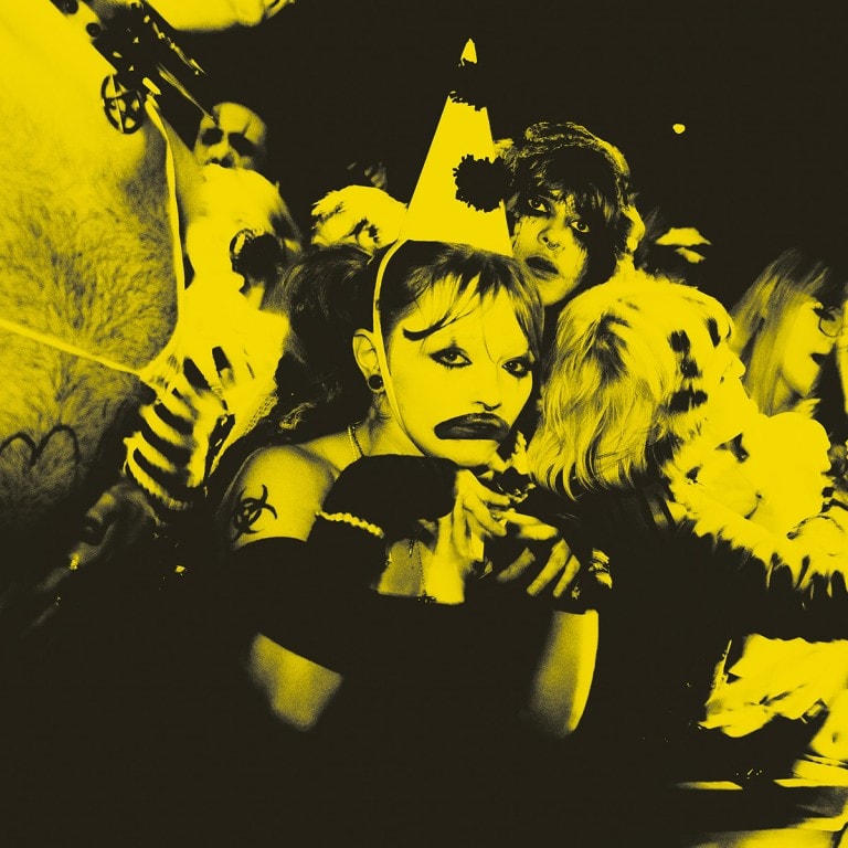 Chaotic party scene with punk fashion and makeup, vibrant yellow filter for edgy aesthetics.