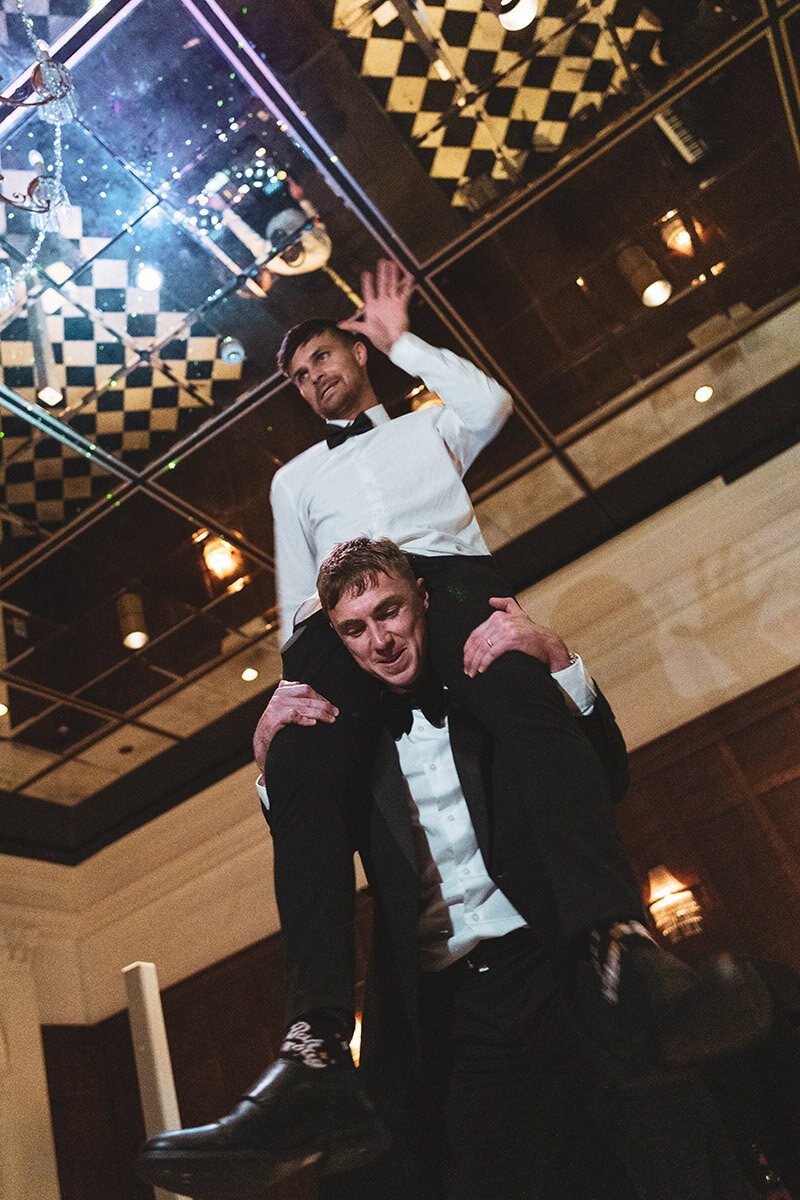 Dancing men in tuxedos performing at party, night event, entertainment, celebration, formal attire, dance performance.