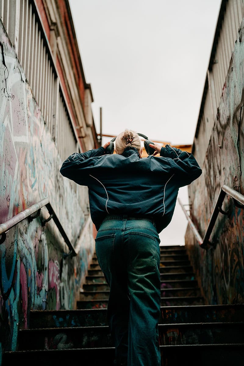 Woman walking up subway stairs, environmental portrait, London