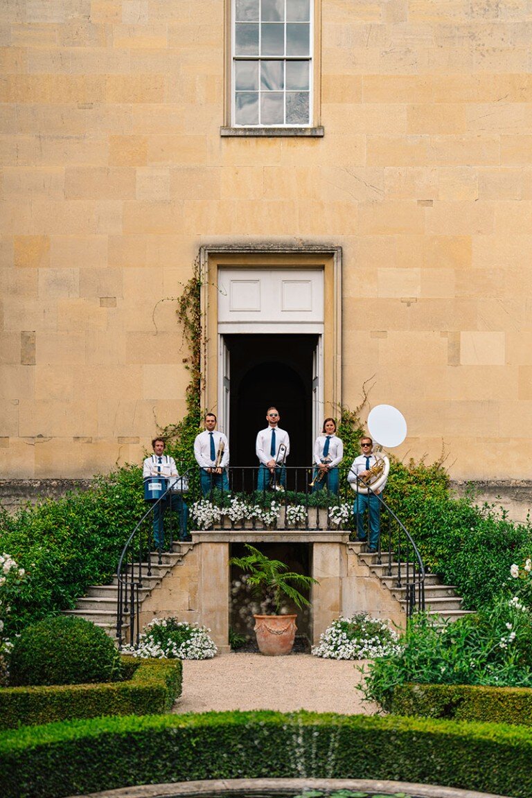 Elegant band performing on a grand balcony at an outdoor event.