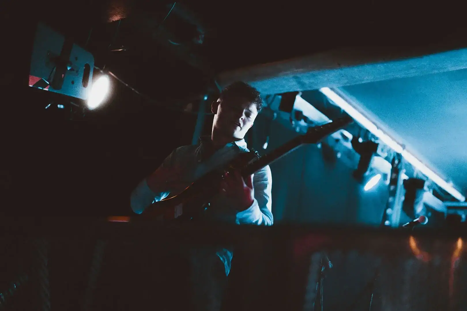Musician at front of stage, dynamic pose, London music event photographer
