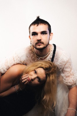 Bold young man with edgy makeup and jewelry, rooted in alternative fashion style.