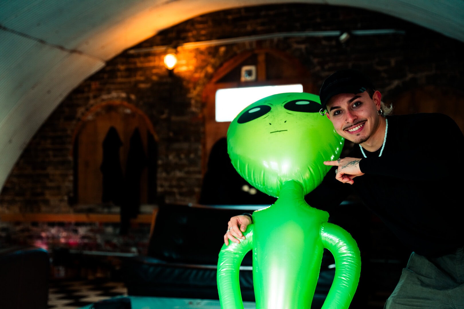 Colorful alien-shaped balloon with a person smiling at the camera at LemonLens.