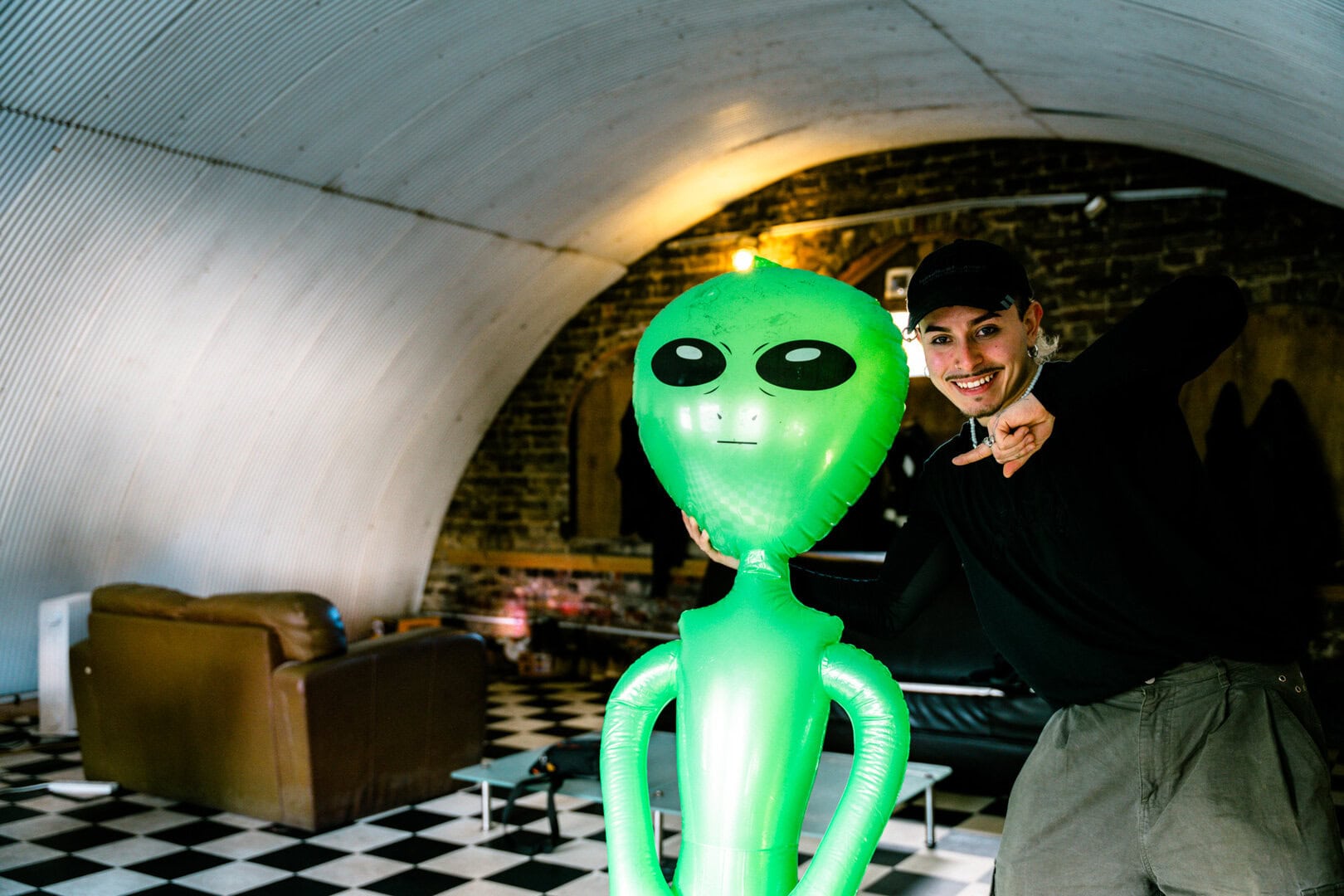 Colourful alien-themed balloon statue in a modern indoor setting.