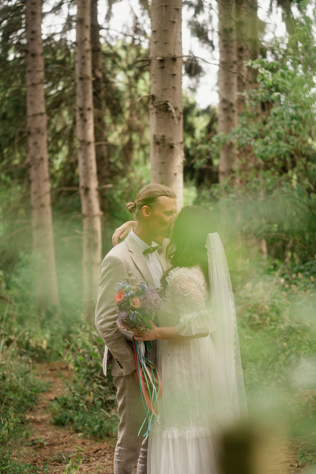 LemonLens wedding photo in forest with couple kissing, romantic outdoor woodland wedding photography.