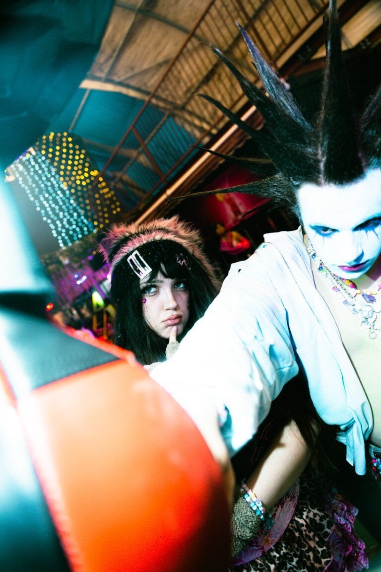 Colorful partygoers with edgy fashion and vibrant neon lighting at a lively nightclub.