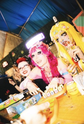 Brightly coloured, eccentric fashionistas playing the board game "Operation" at LemonLens event, showcasing vibrant style and party atmosphere.