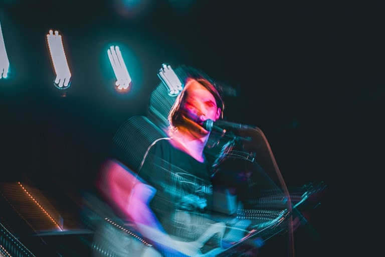 Dynamic performer with motion blur effects during live music show.