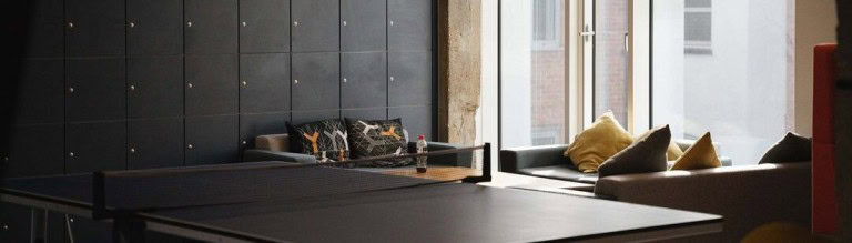 Modern indoor sports lounge with ping pong table and cosy seating area.