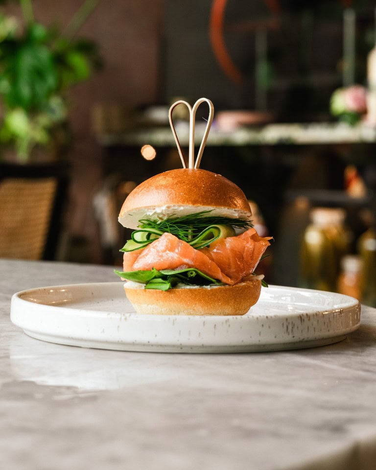 Delicious gourmet sandwich with fresh ingredients and elegant presentation on a white plate, perfect for a refined meal or special occasion.