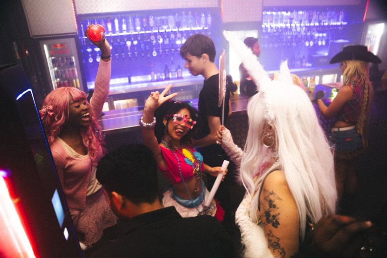 Vibrant party scene with friends enjoying a lively night out, capturing the fun atmosphere in a nightclub with colourful lighting.