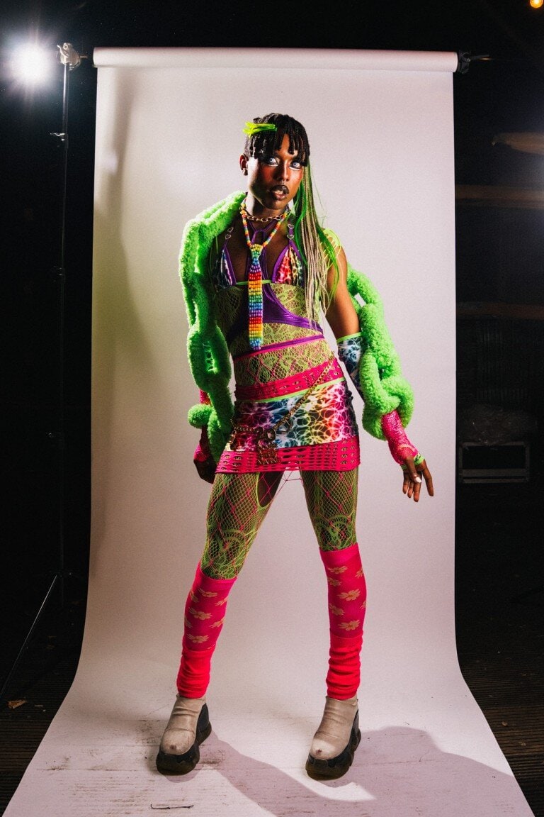 Vibrant colourful fashion shoot featuring layered neon clothing, accessories, and creative styling in a professional studio environment.