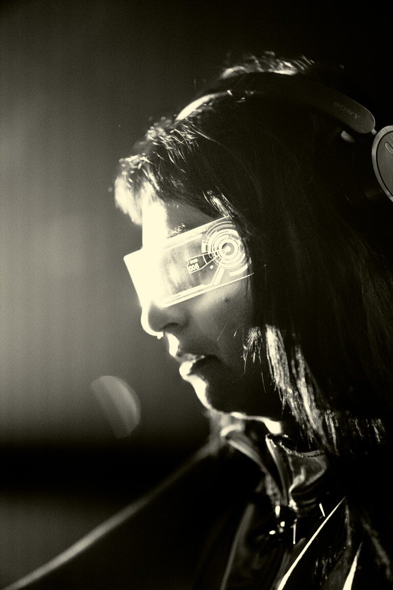 Futuristic individual wearing high-tech augmented reality glasses, with a sleek design and advanced digital interface projected onto the lenses.