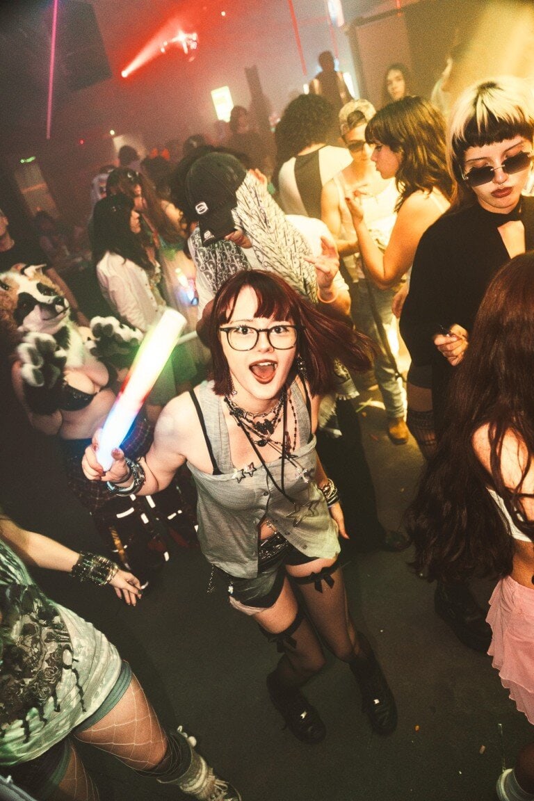 People dancing at a nightclub, vibrant party scene, colourful lighting, electronic dance music atmosphere, nightlife photography, concert photography, event photography, UK.