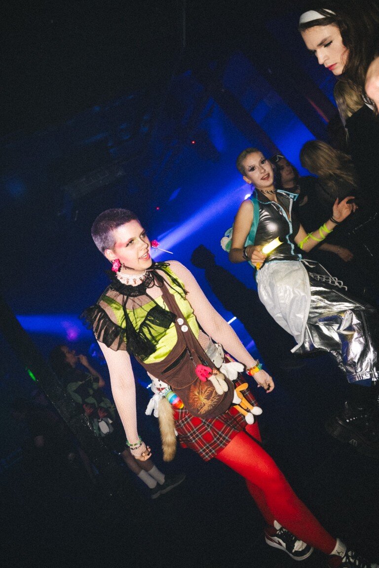 Brightly dressed individuals enjoying a lively party scene with colourful outfits and energetic atmosphere.