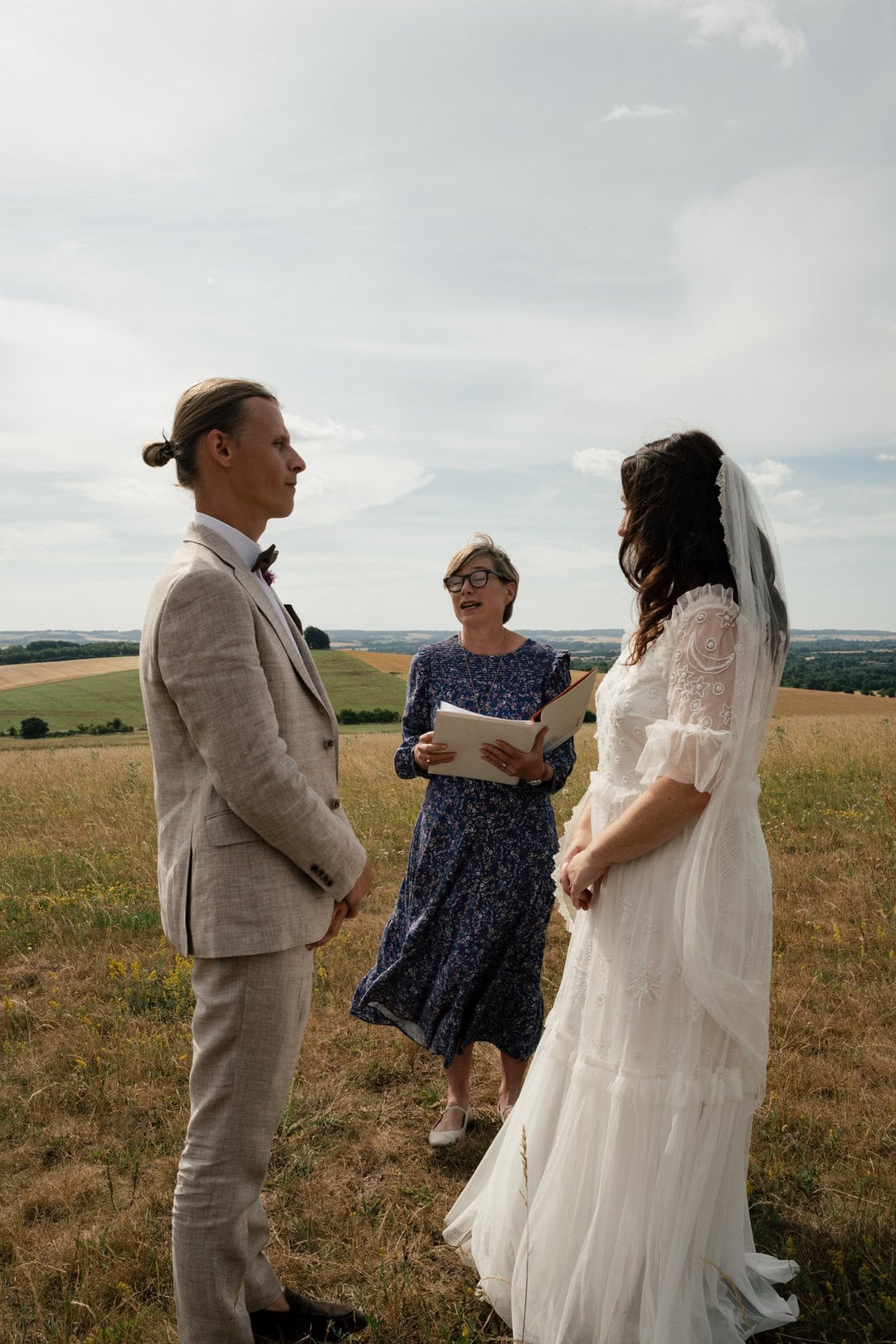 Elegant outdoor wedding ceremony in a scenic rural landscape, captured in natural light for romantic wedding photography.